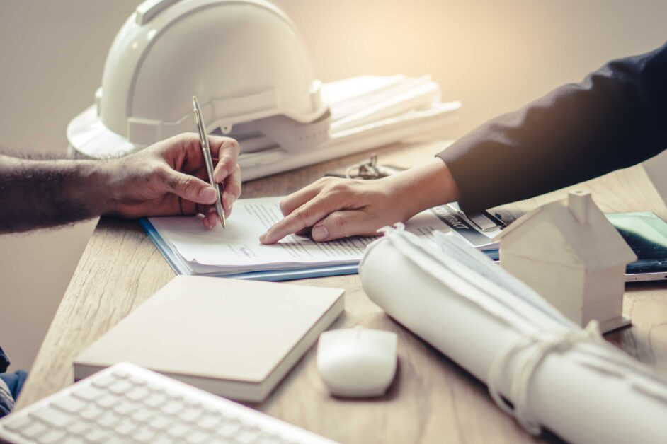 Comprehensive general liability insurance for contractors: legal paper being signed with hard hat on desk