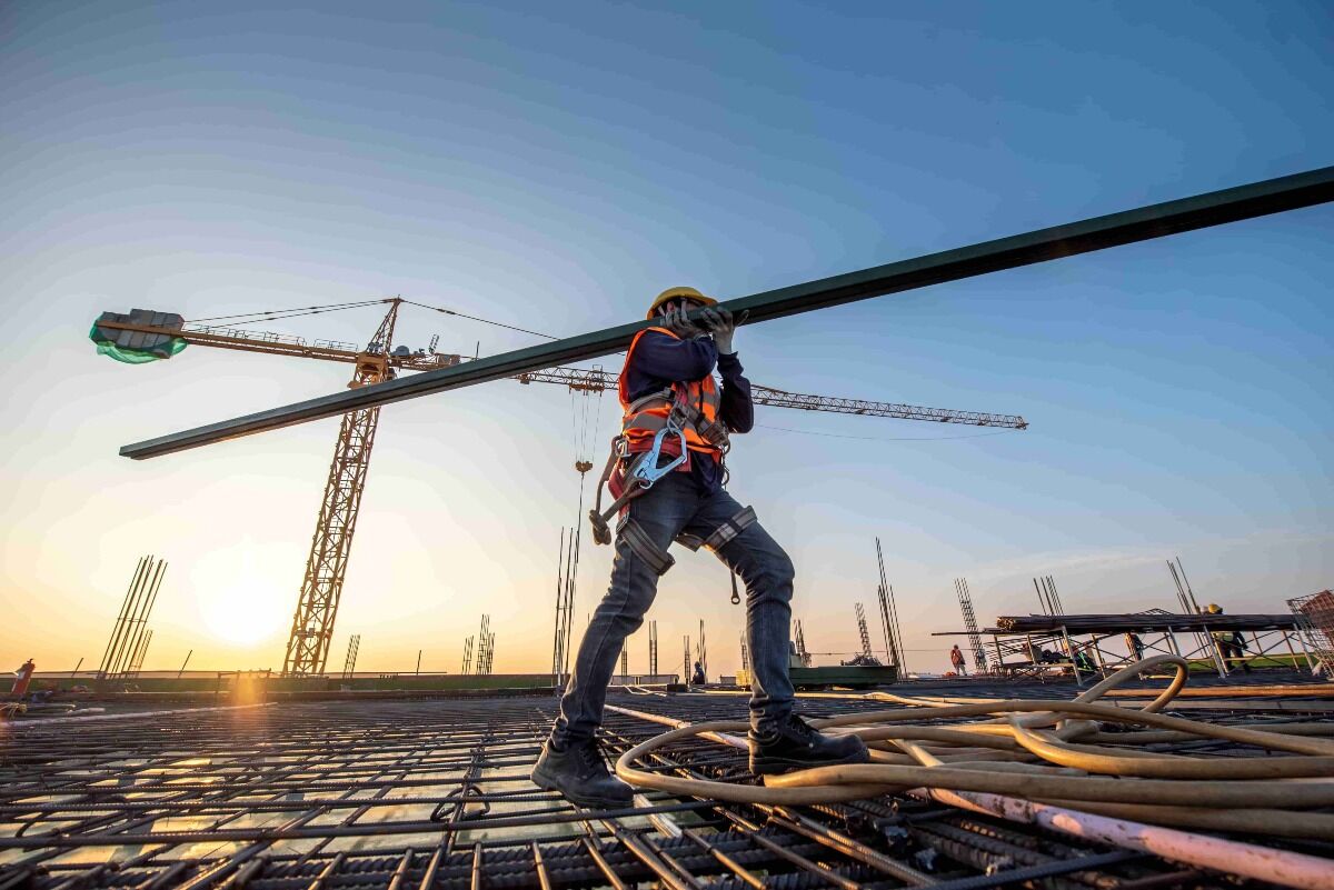 construction worker carrying beam