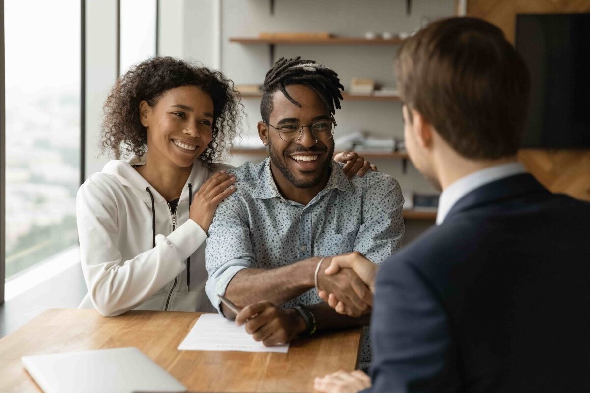 couple shaking hands with an insurance agent