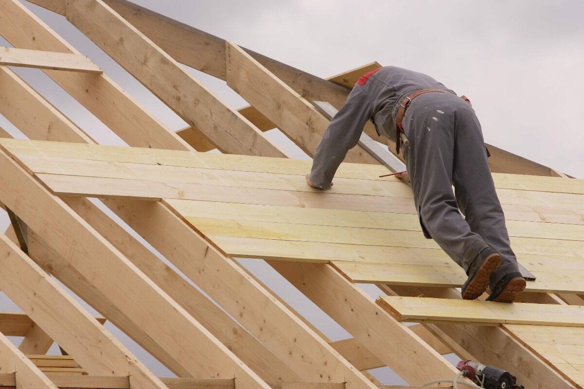 roofing professional putting boards on wood frame