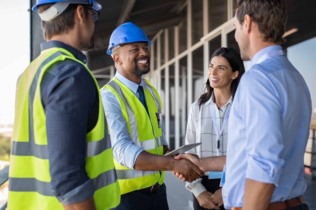 construction worker shaking hands with an insurance broker